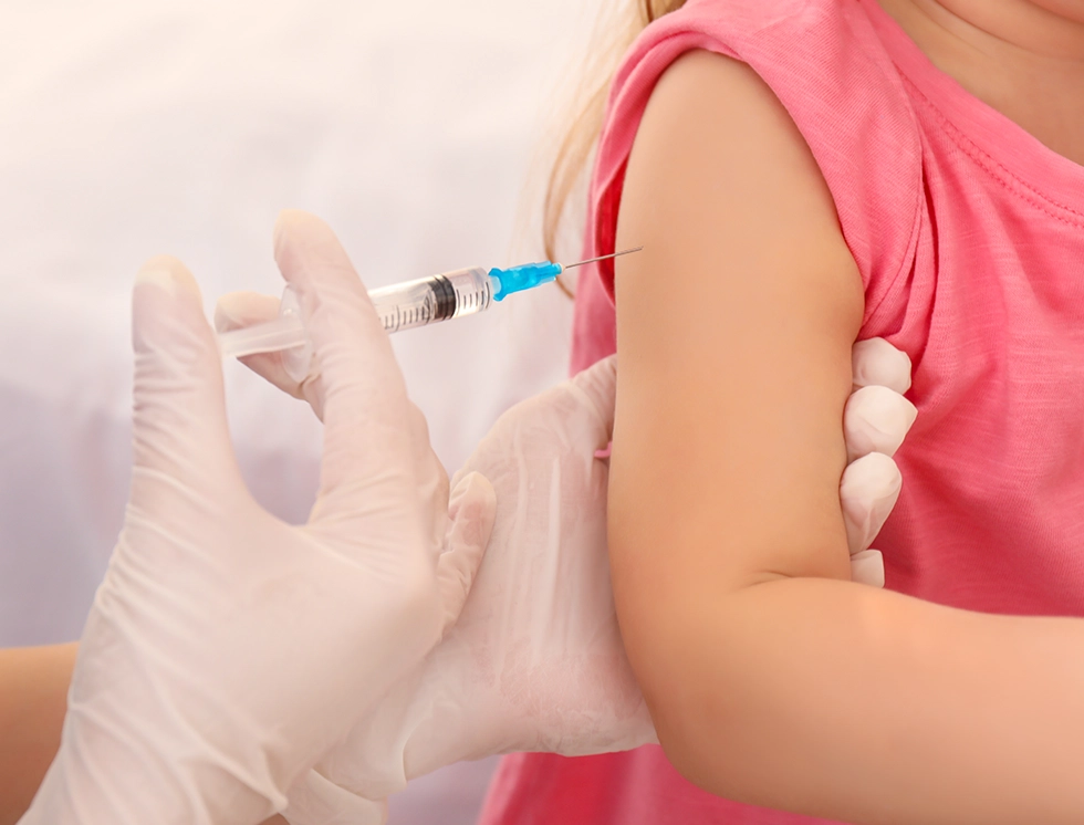 A healthcare professional administers a vaccine to a young child's arm, ensuring a safe vaccination process.